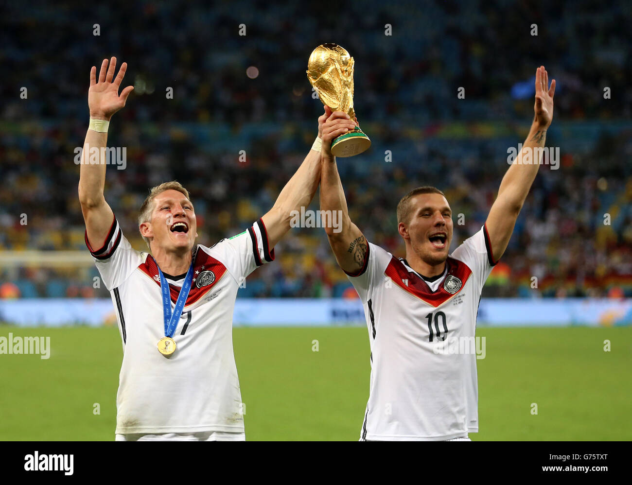 Germany's Bastian Schweinsteiger (left) and Lukas Podolski celebrate winning the World Cup after the FIFA World Cup Final at the Estadio do Maracana, Rio de Janerio, Brazil. Stock Photo