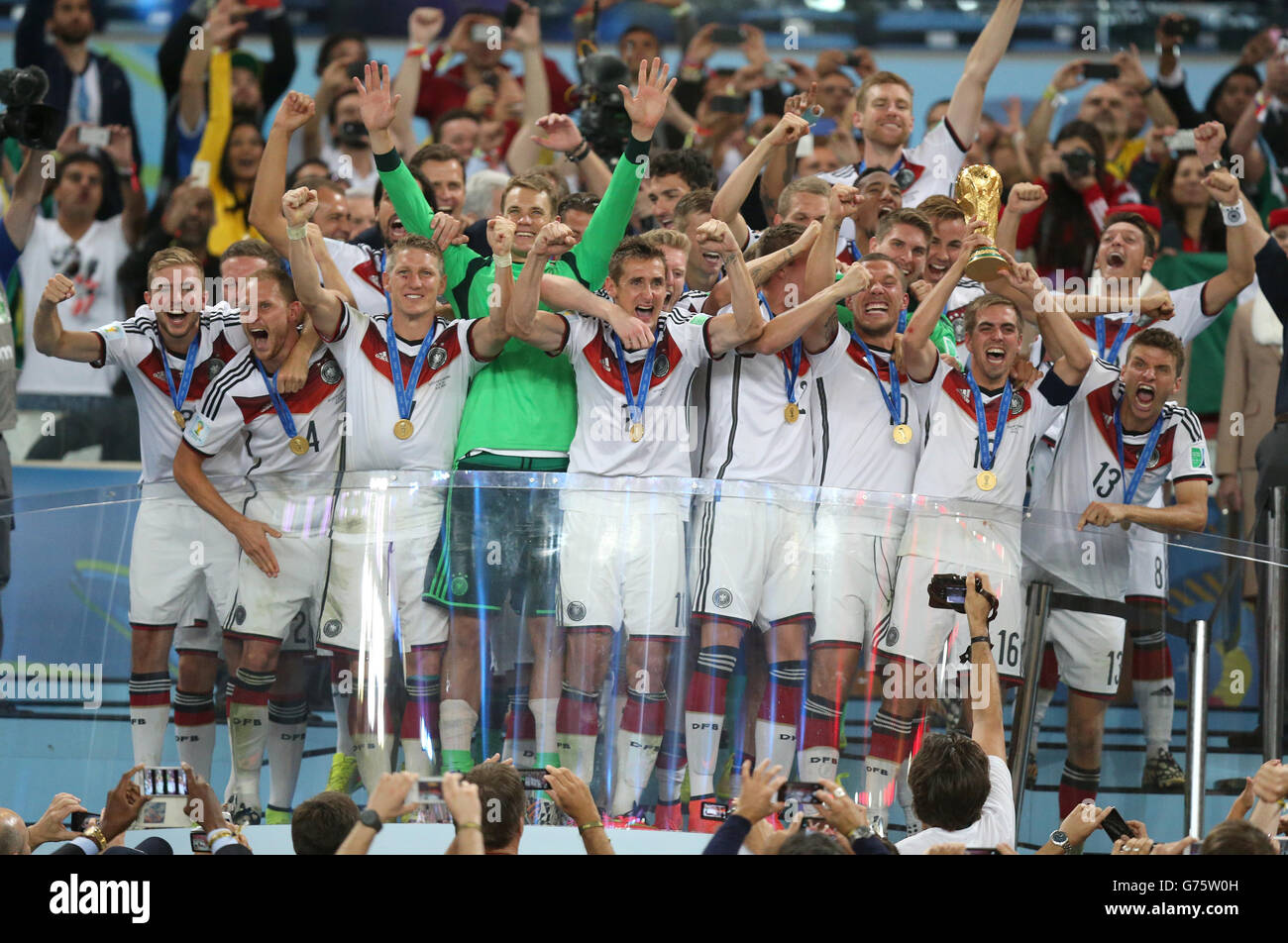 Germany's Philipp Lahm lifts the World Cup and celebrates victory with team-mates after the FIFA World Cup Final at the Estadio do Maracana, Rio de Janerio, Brazil. Stock Photo