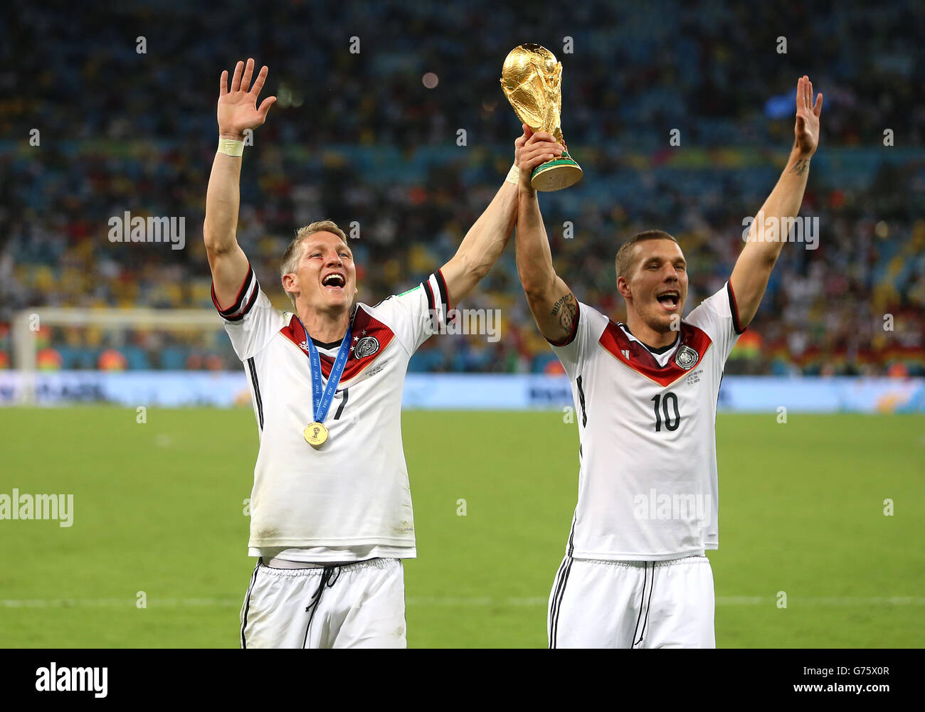 Germany's Bastian Schweinsteiger and Lukas Podolski (right) celebrate with the World Cup trophy Stock Photo