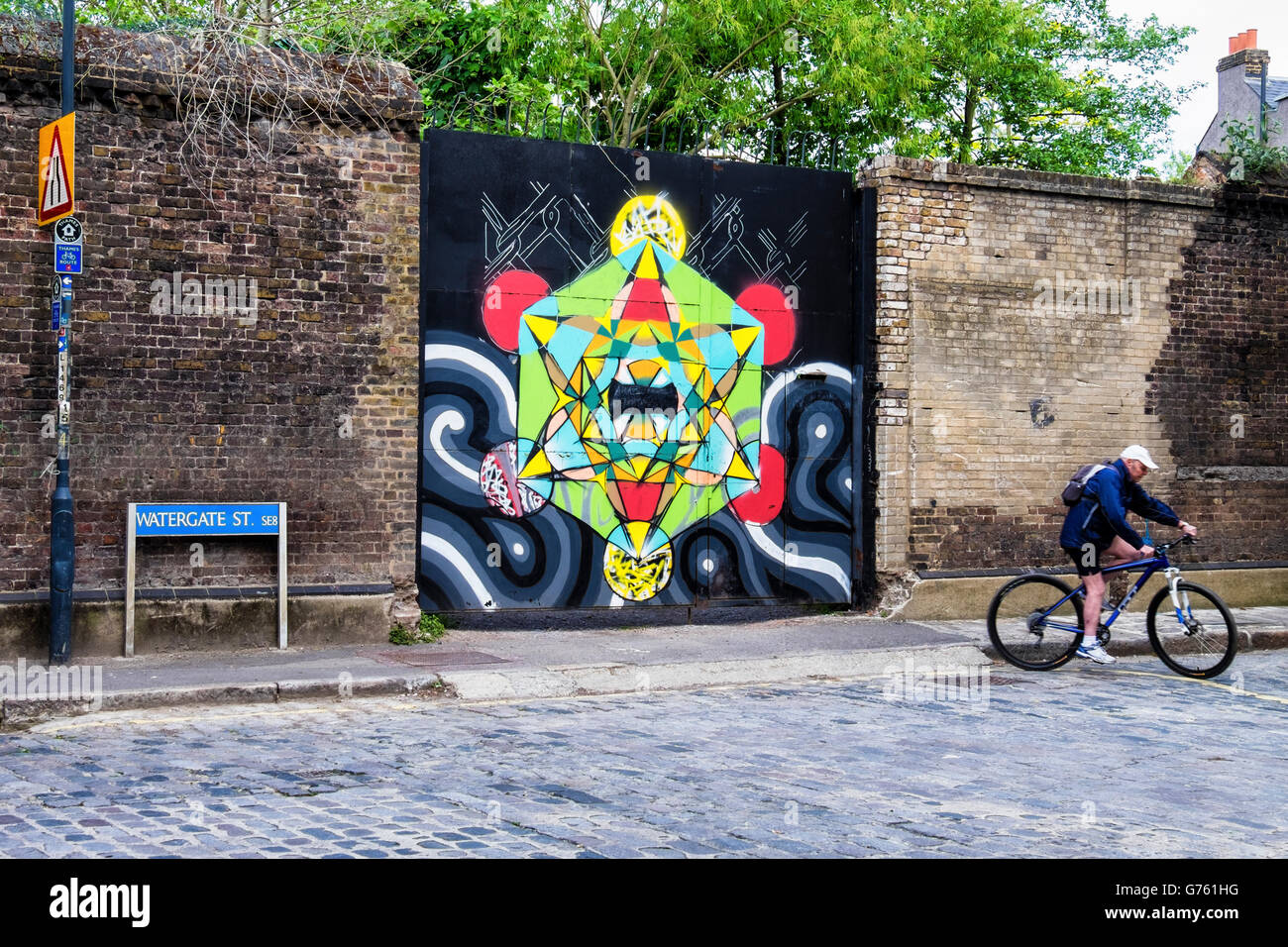 Mural street art in Deptford, London and senior male tourist on Bicycle Stock Photo