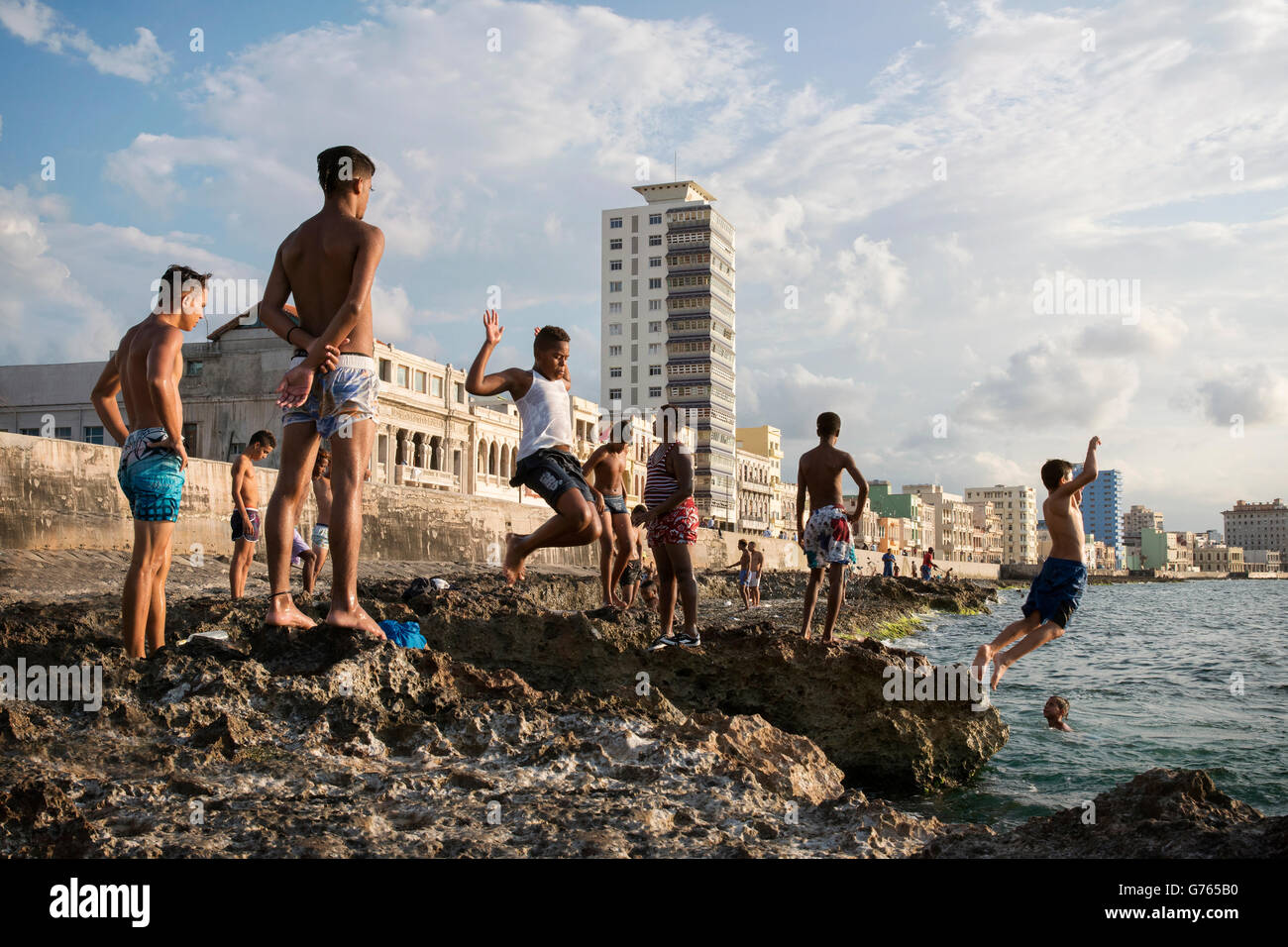 Local boys diving into the sea from the rocks in front of The Malecon (coast road) in Havana, Cuba Stock Photo