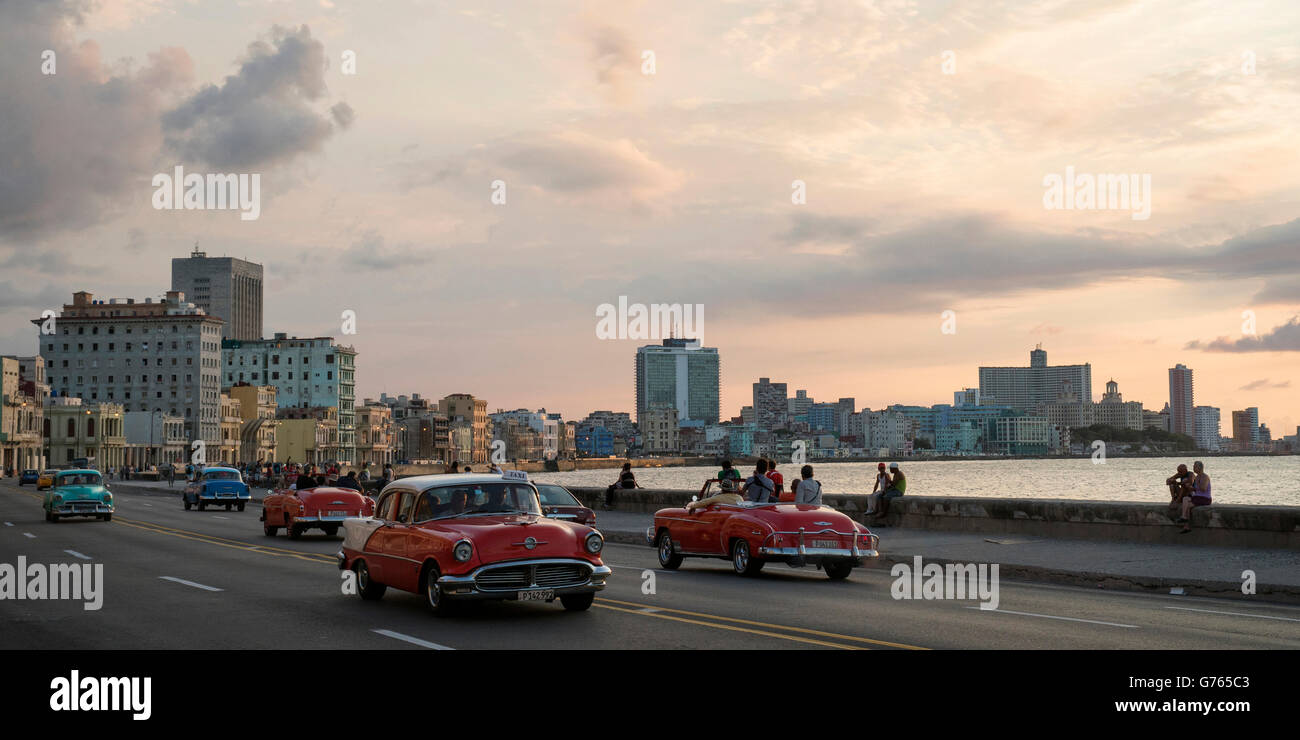 Classic cars driving along The Malecon (coast road) in Havana, Cuba Stock Photo