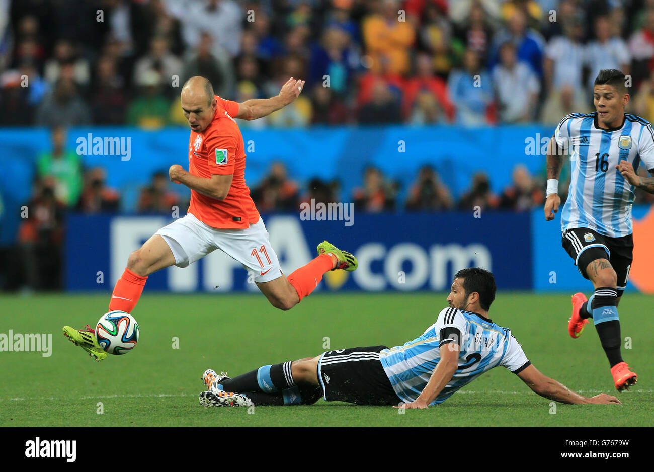 Netherland's Arjen Robben (left) skips the tackle from Argentina's Ezequiel Garay (right) Stock Photo
