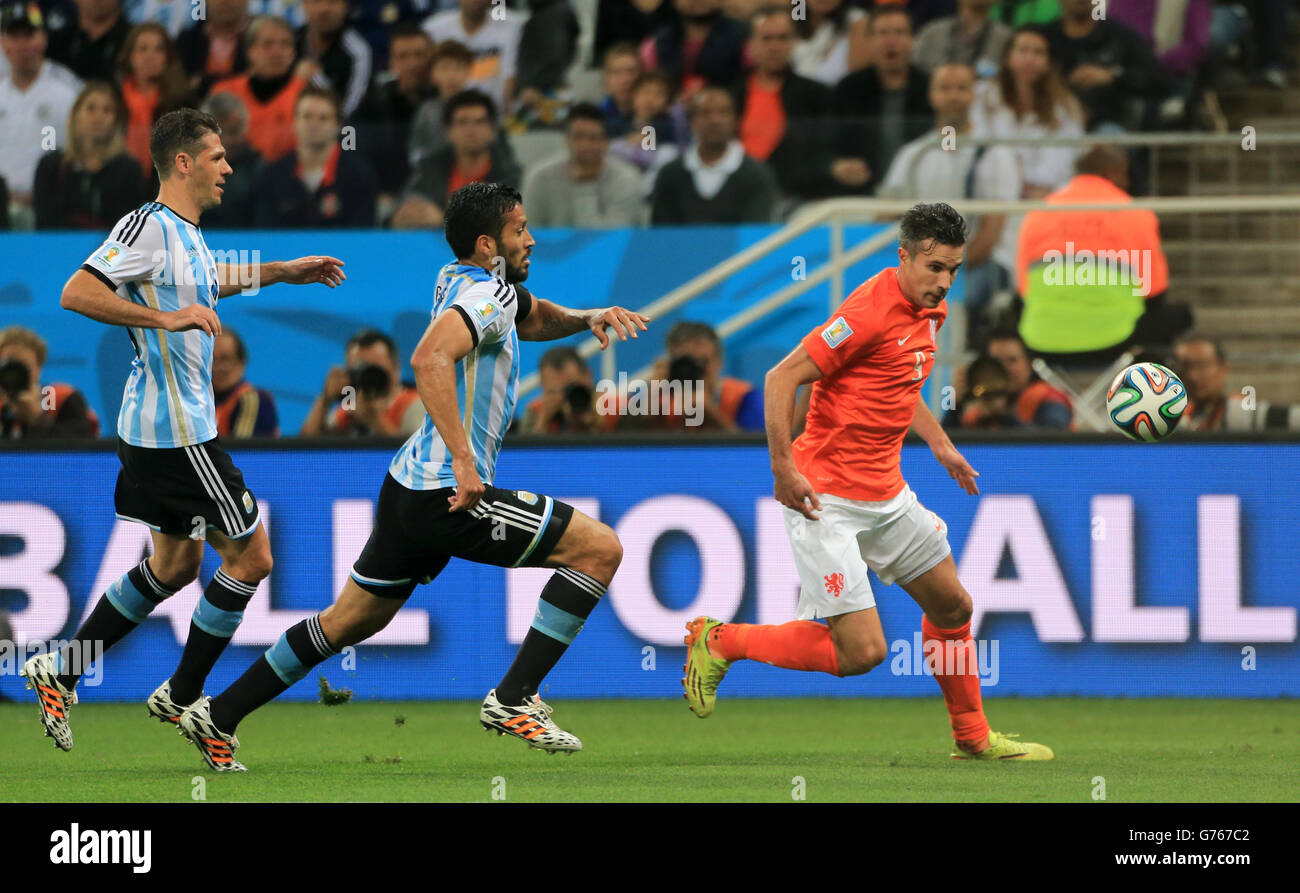 Soccer - FIFA World Cup 2014 - Semi Final - Netherlands v Argentina - Arena de Sao Paulo. Argentina's Ezequiel Garay (left) attempts to tackle Netherland's Robin van Persie (right) Stock Photo