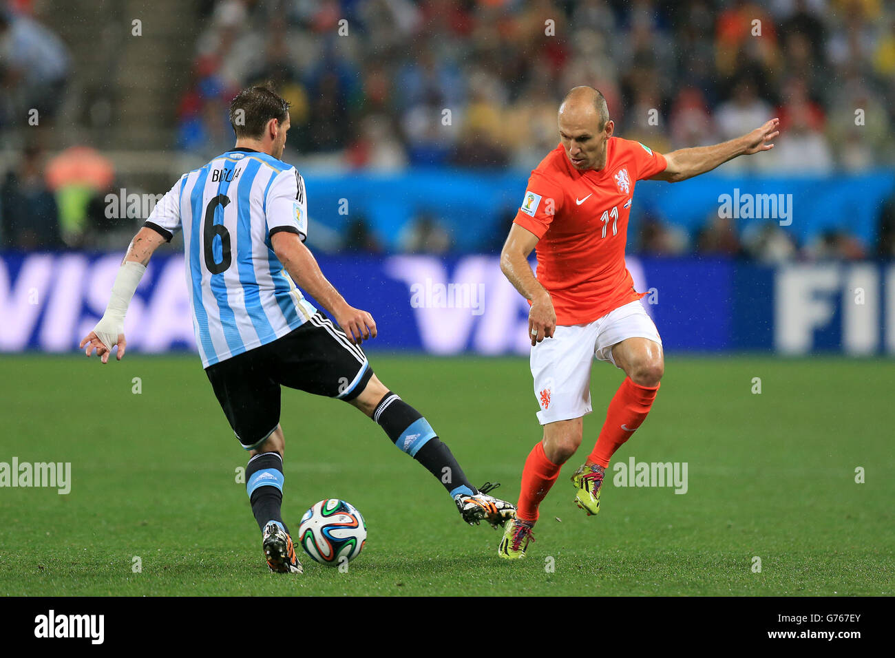 Netherlands' Arjen Robben (right) and Argentina's Lucas Biglia battle for the ball during the FIFA World Cup Semi Final at the Arena de Sao Paulo, Sao Paulo, Brazil. Stock Photo
