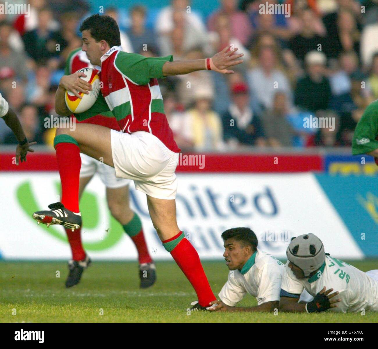 Wale's Emyr Lewis rides the Sri Lankan tackle during a pool match at the Rugby 7's at the 2002 Commonwealth Games in Manchester. Stock Photo