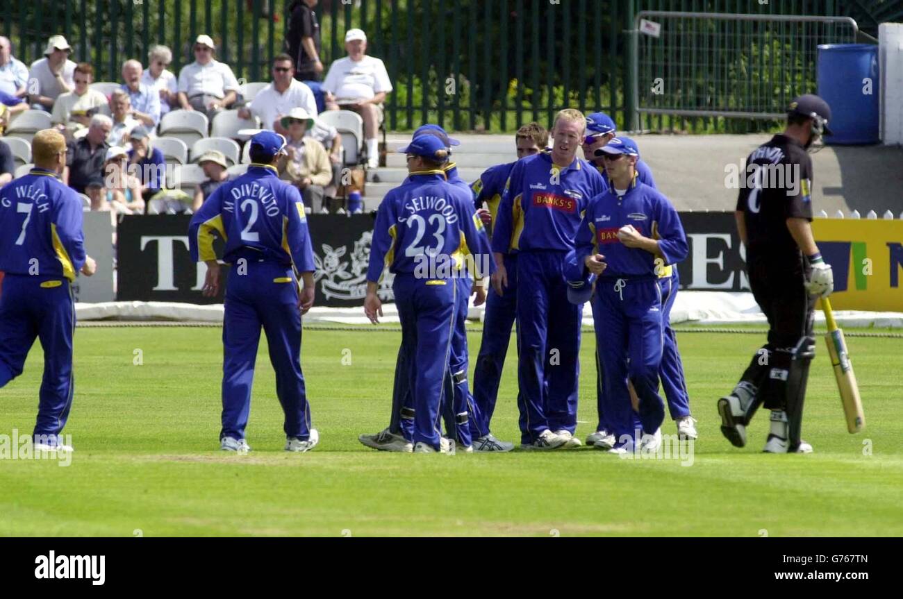 Neil Johnson of the Hampshire Hawks (right) departs, caught Andrew Gait, bowled Kevin Dean (centre) for 14 runs during the Norwich Union League Division Two game between Derbyshire Scorpions and Hampshire Hawks at the County Ground, Derby. Stock Photo