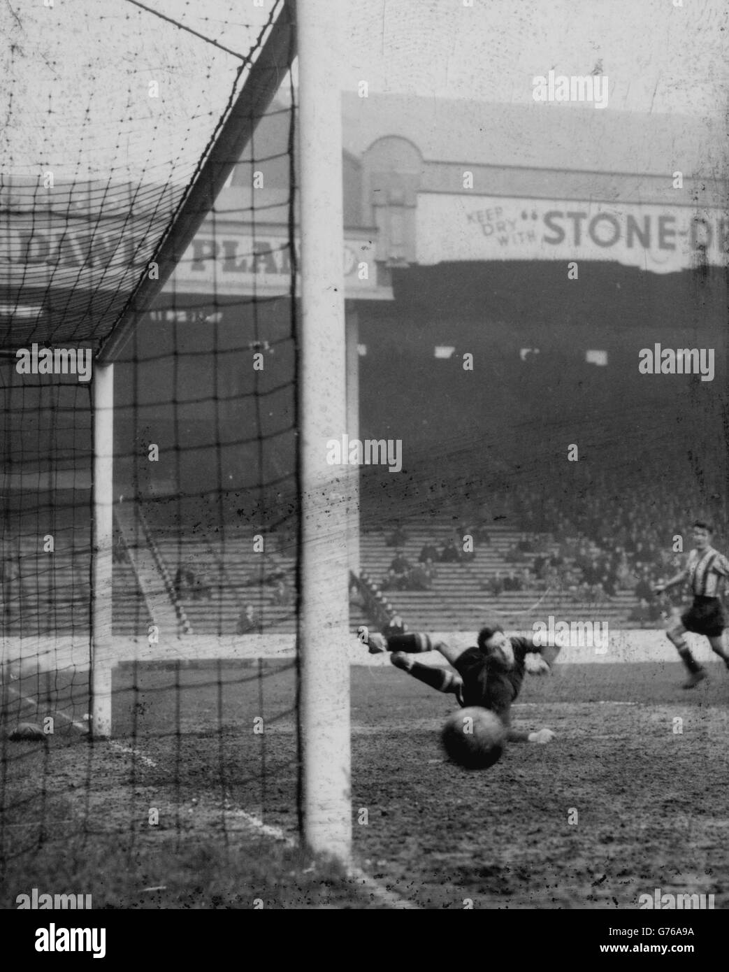 Sheffield United goalkeeper Alan Hodgkinson is well beaten by a cross-shot from Huddersfield Town centre-forward Dave hickson (extreme right) in the second replay of the FA Cup thrid round tie at Maine Road. The ball hit the post and rebounded to Huddersfield Town wing half, who scored the equalising goal. A later goal by Hickson gave Huddersfield Town victory by two goals to one. Stock Photo