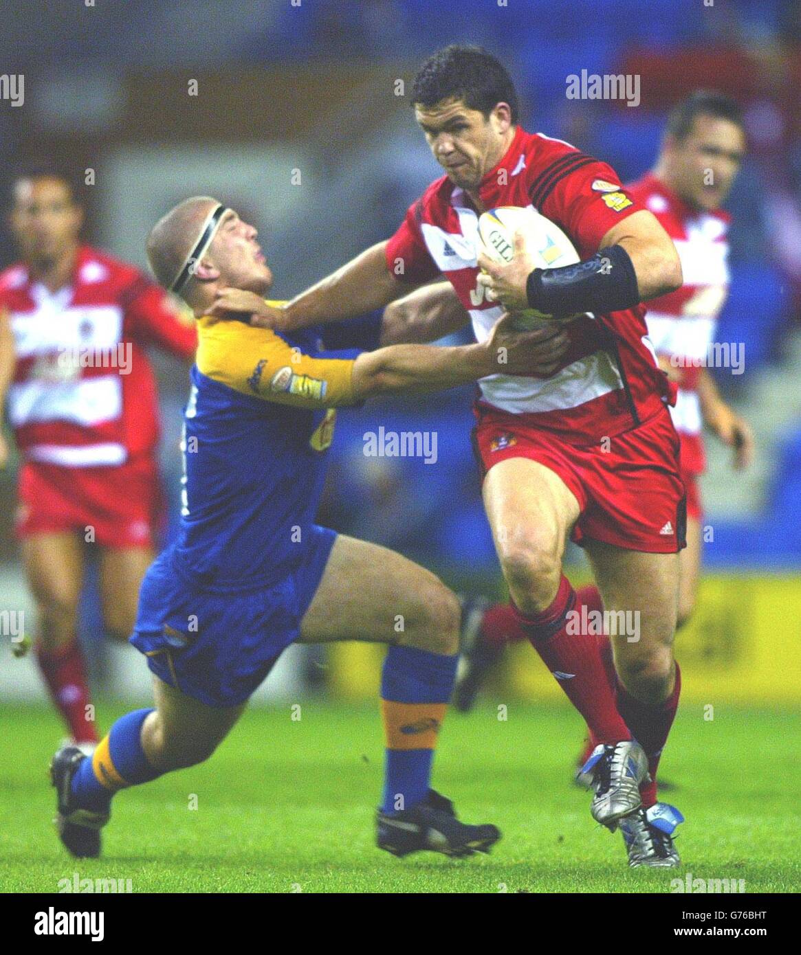 Wigan Warriors Andrew Farrell (right) holds off a tackle by Leeds Rhinos Matt Diskin, during the Tetleys Super League Semi-Final at the JJB Stadium in Wigan. Stock Photo