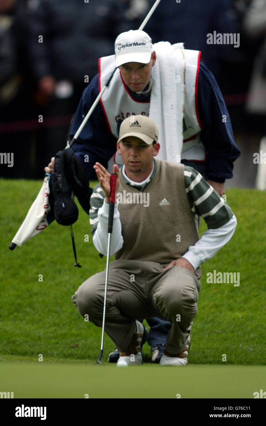 Sergio Garcia checks the line on the 2nd green with caddy Glenn Murray