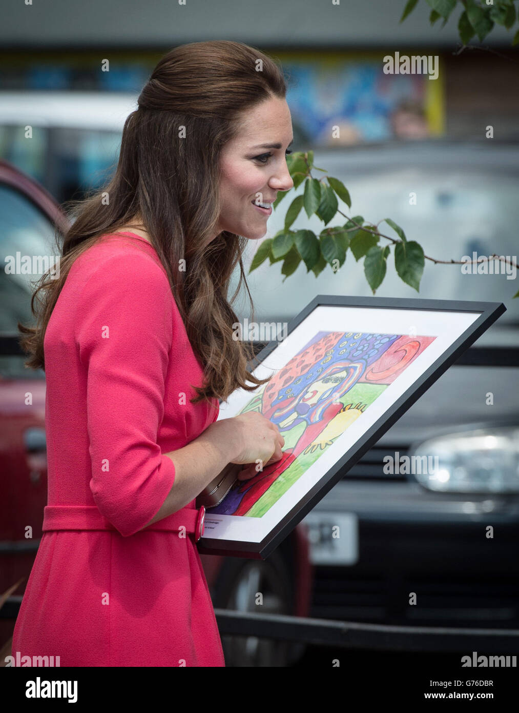 The Duchess of Cambridge is presented with a portrait of herself and Prince George by 11-year-old Rosie Nee, painted in the style of Picasso by the pupils of Blessed Sacrament Catholic School in Islington, north London, during a visit by the Duchess to see first-hand the work of a project she launched to help families affected by addiction. Stock Photo