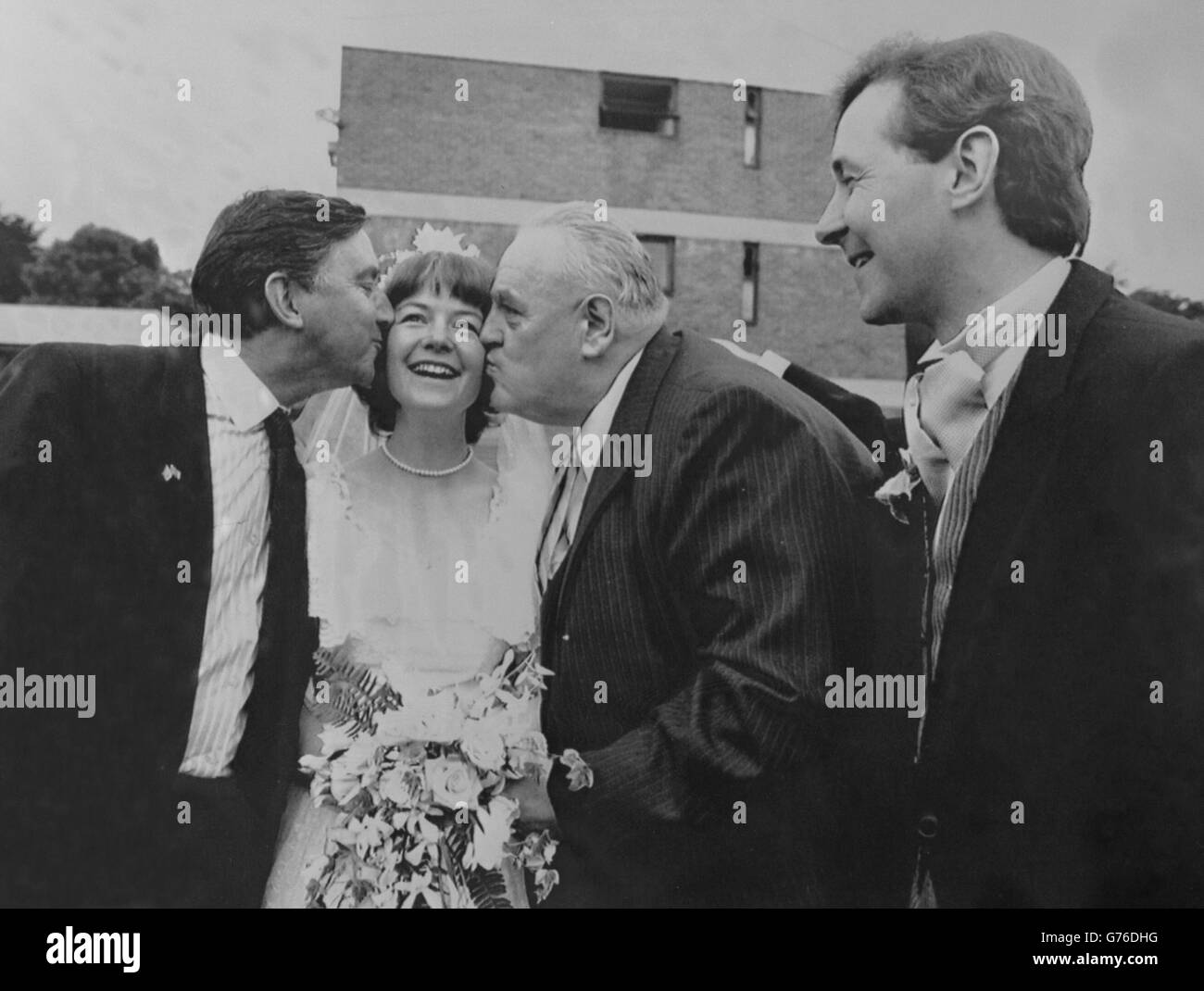 Social and Liberal Democrat MP David Alton looks on as SLD joint leader David Steel (r) and MP Cyril Smith steal a kiss from his bride, 34-year-old speech therapist Lizzie Bell, after their wedding in the chapel of Christ and Notre Dame College in Woolton, Liverpool. Stock Photo