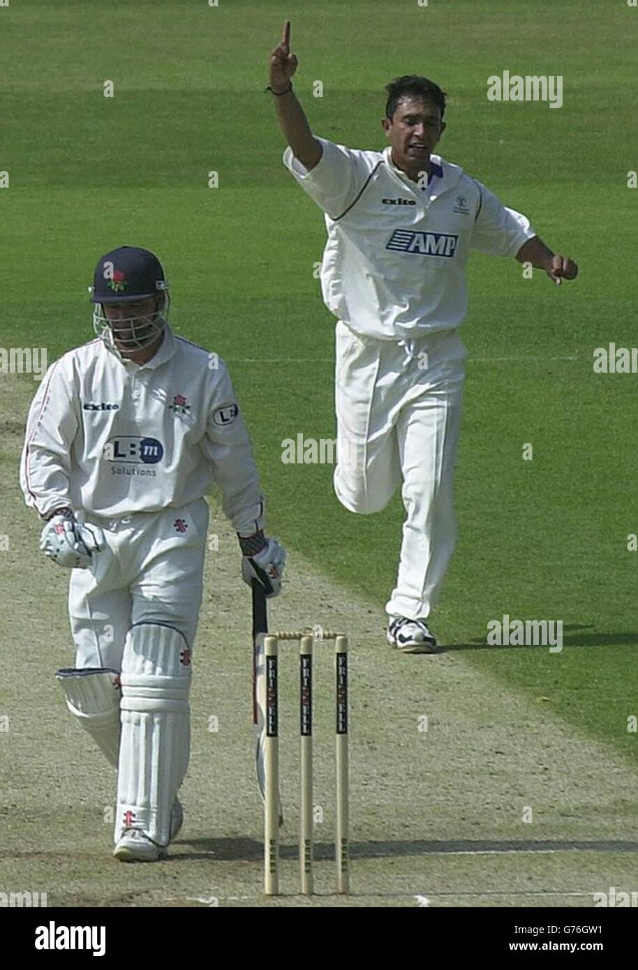 Lancashire batsman and wicketkeeper, Warren Hegg, leaves the field as Surrey bowler Ahzar Mahmood celebrates having dismissed him for nine on the first day of their county fixture at The Oval, London. Stock Photo