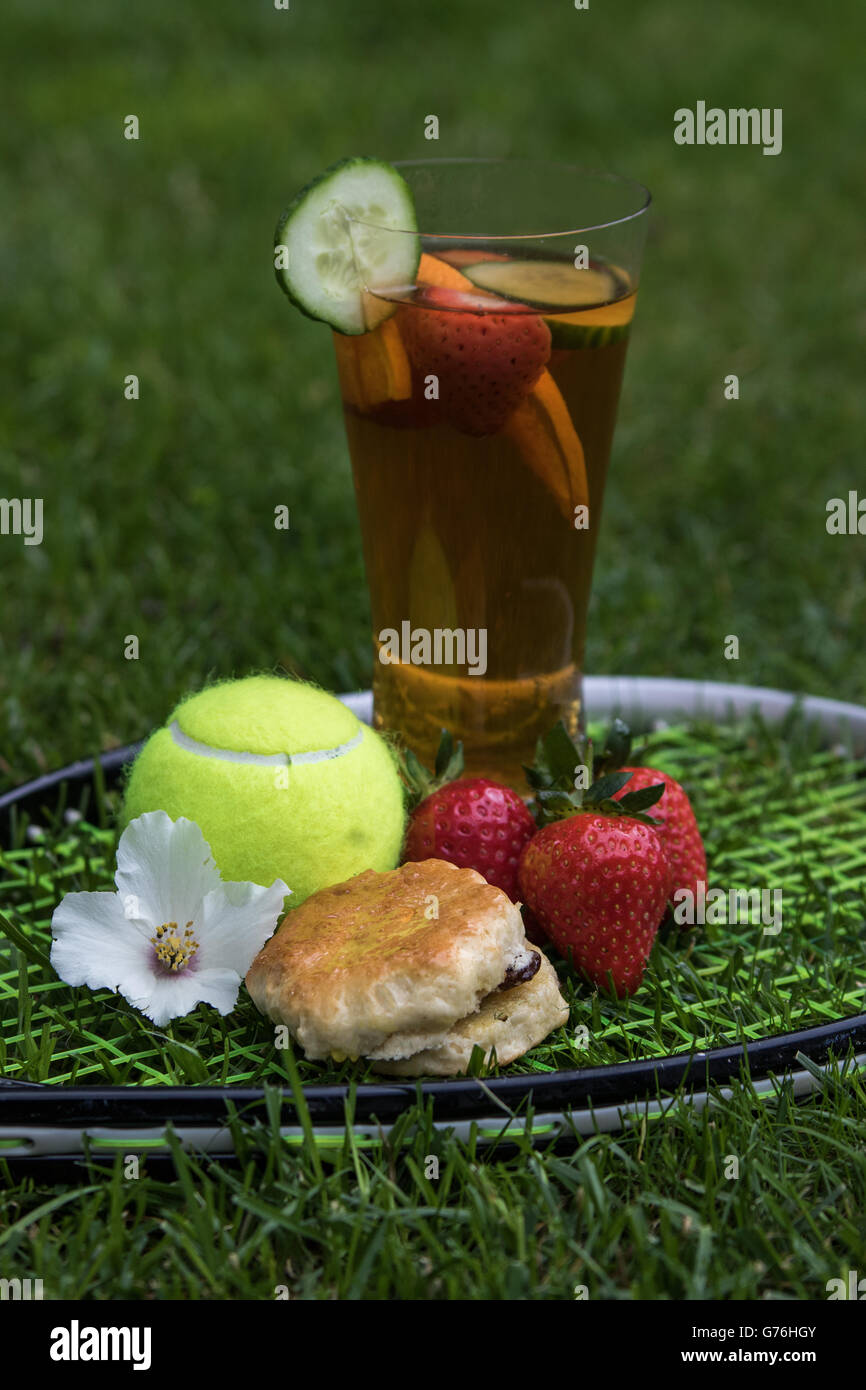 Summer picnic set out on a tennis racket on grass with flower Stock Photo