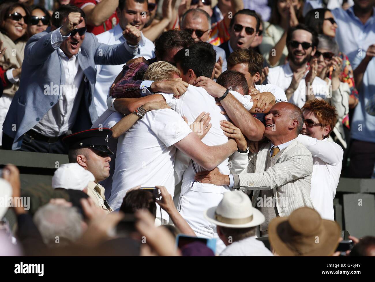 Serbia's Novak Djokovic celebrates defeating Switzerland's Roger Federer with his coaching team in the players box, following the Mens' Singles Final during day fourteen of the Wimbledon Championships at the All England Lawn Tennis and Croquet Club, Wimbledon. Stock Photo
