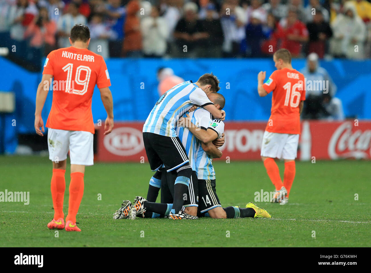 Argentina's Lucas Biglia (centre left) and Javier Mascherano (centre right) celebrate victory in the penalty shoot-out as Netherlands' Klaas Jan Huntelaar (left) and Jordy Clasie (right) are left dejected, during the FIFA World Cup Semi Final at the Arena de Sao Paulo, Sao Paulo, Brazil. Stock Photo