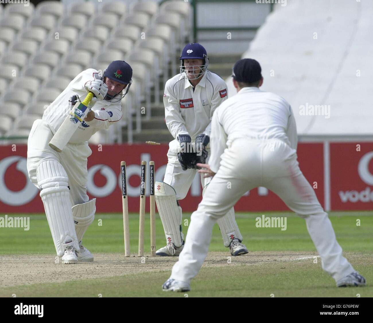 Lancashire's David Byas (former Yorkshire captain) is clean bowled Yorkshire's Anthony McGrath for with wicketkeeper Richard Blakey (centre) during the Frizzell County Championship Division One, Old Trafford, Manchester. Stock Photo