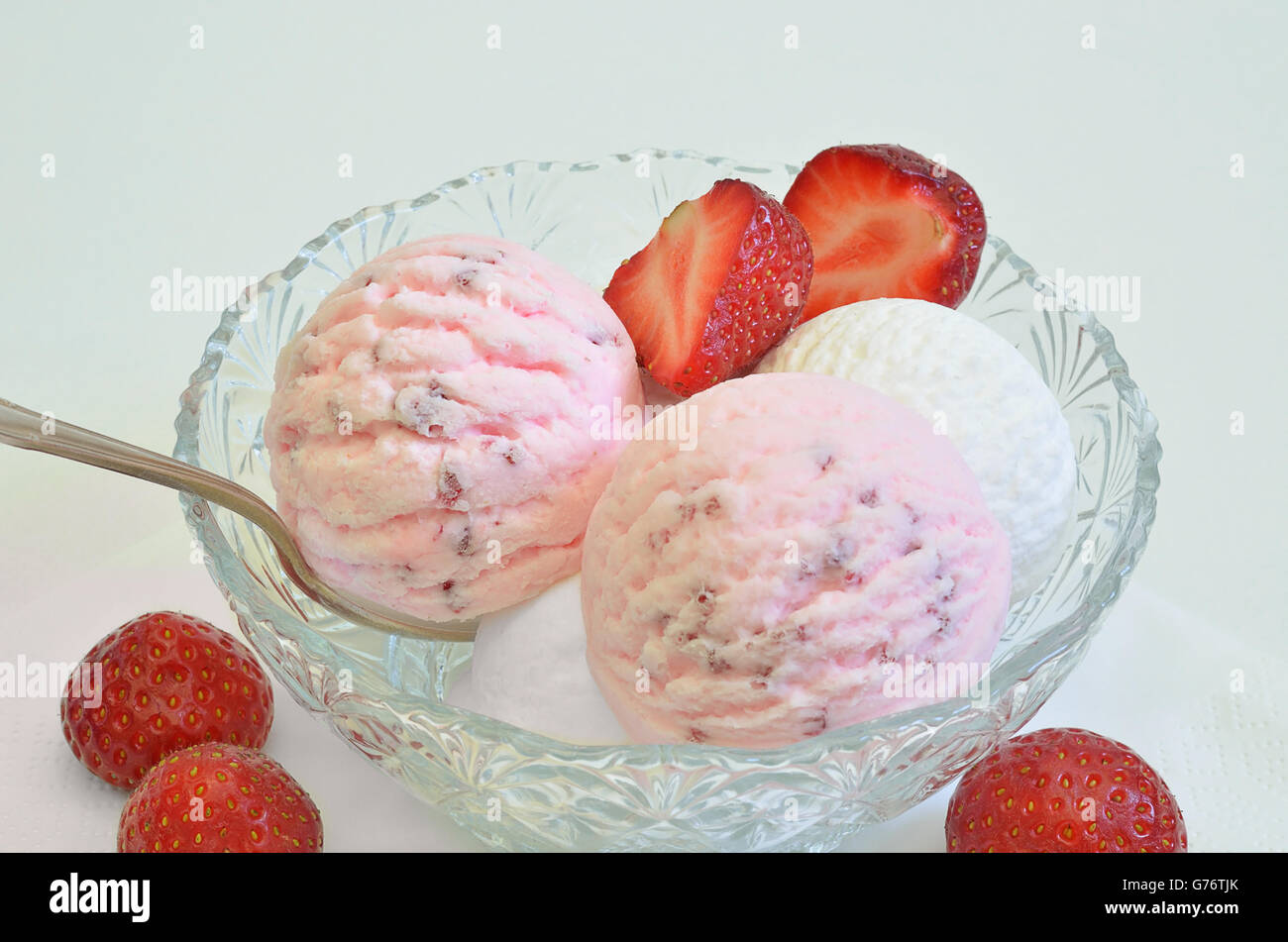scoops of strawberry ice cream and vanilla ice cream in a bowl  with fresh strawberries, macro, detail, white background Stock Photo