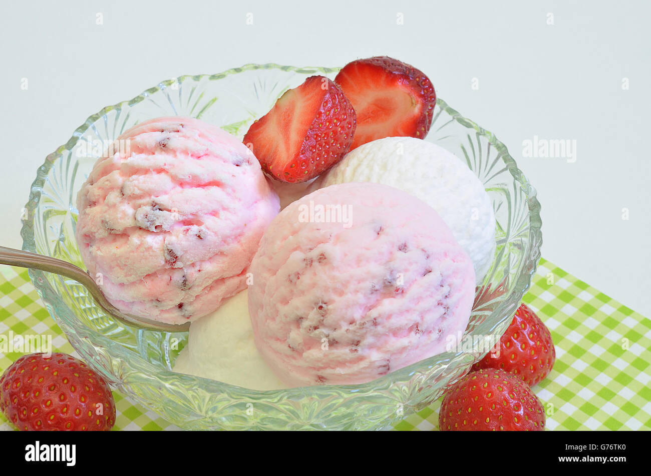 scoops of strawberry ice cream and vanilla ice cream in a bowl with fresh strawberries, macro, close up, full frame, horizontal Stock Photo