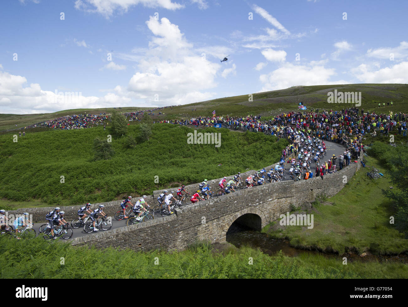 Cycling - Tour de France - Stage One - Leeds to Harrogate. The peloton rides over a bridge on Grinton Moor as stage one of the Tour de France passes over the Grinton Moor, Yorkshire. Stock Photo