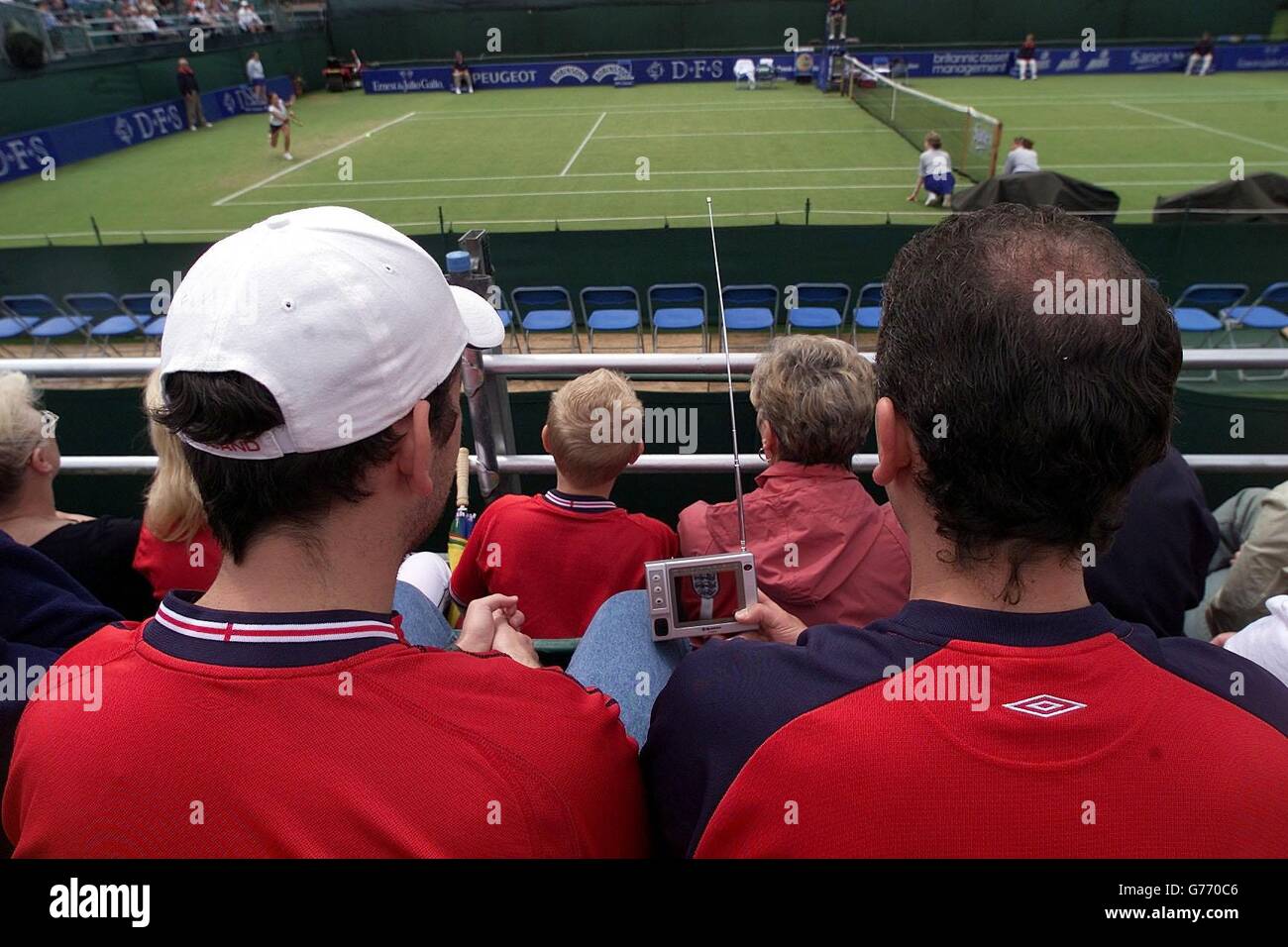 England fans keep in touch with the England v Denmark World Cup game on mini TV at the DFS Classic at the Priory Club, Edgbaston, Birmingham. Stock Photo