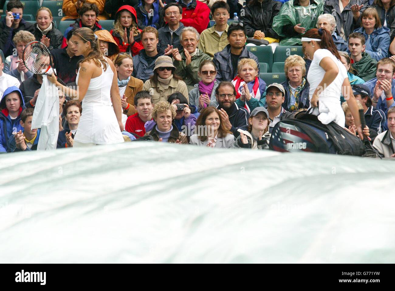 , NO COMMERCIAL USE. Amelie Mauresmo of France, the 9th seed (left) and Jennifer Capriati, the 3rd seed from the USA leave the court during a rain break in the first set at Wimbledon. Rain interrrupted play on several occasions. Stock Photo
