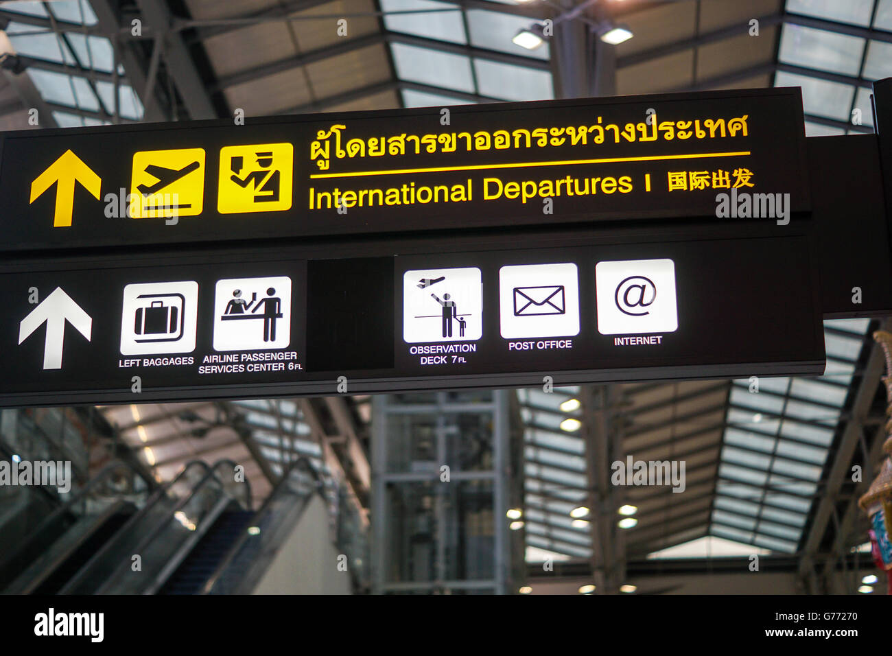 International departures - illuminated yellow sign at airport Stock Photo