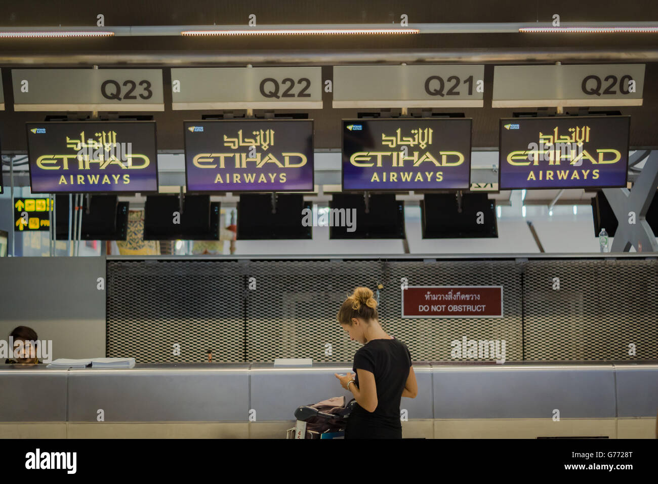 Travellers at Etihad Airways check-in counter in international airport Stock Photo