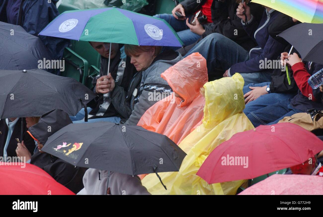 Rain delay at Wimbledon 2002. EDITORIAL USE ONLY, NO COMMERCIAL USE Tennis fans sit in the