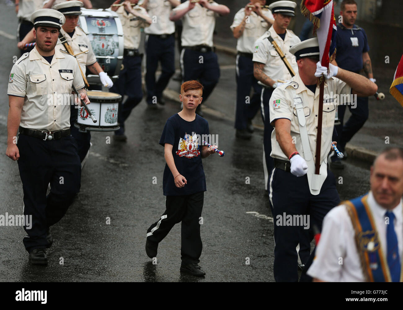 An Orange Order parade on Crumlin Road adjacent to the nationalist Ardoyne neighbourhood as part of the annual Twelfth of July celebrations, marking the victory of King William III's victory over James II at the Battle of the Boyne in 1690. Stock Photo