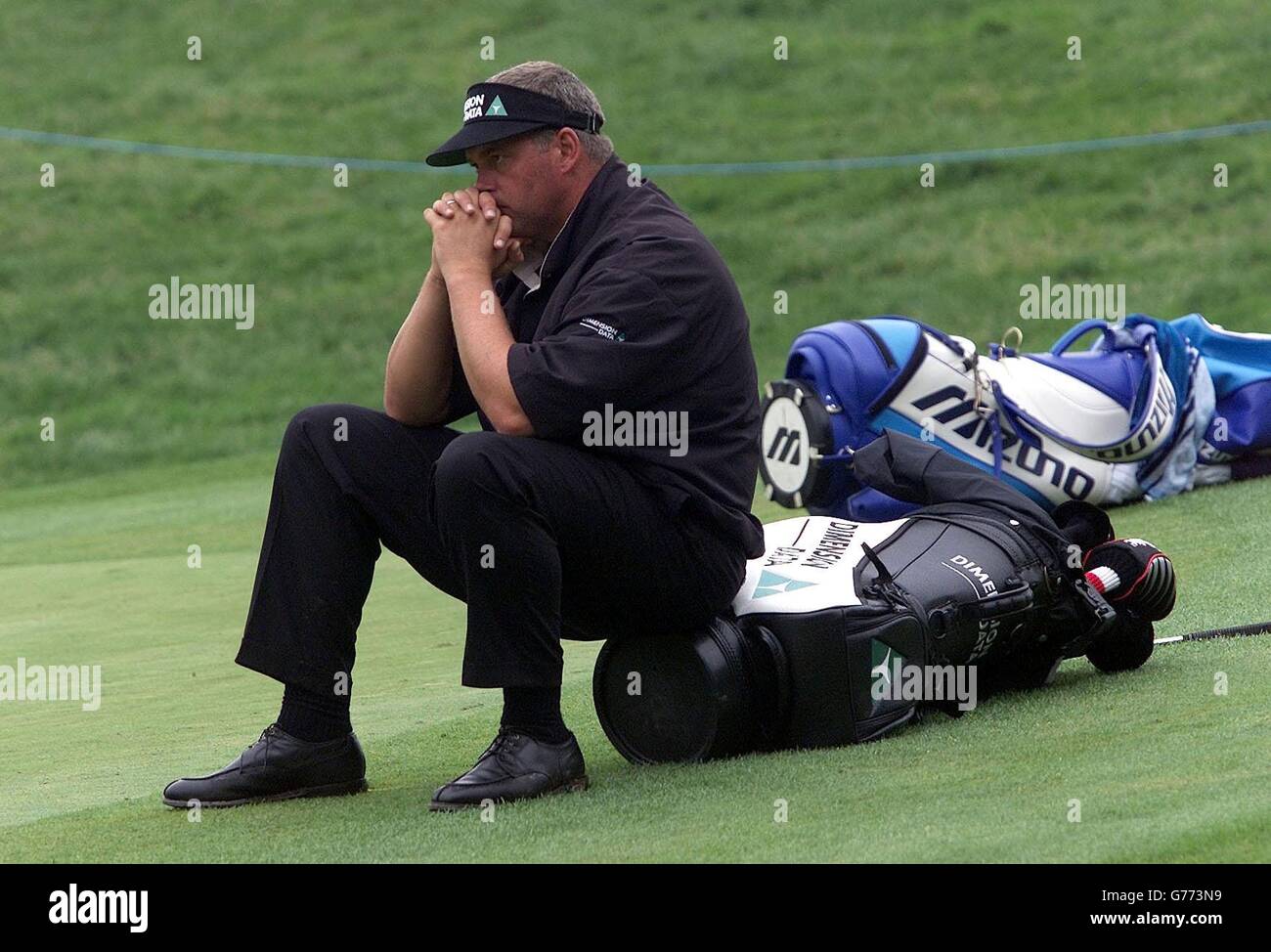 Darren Clarke of Ireland sits on his bag on the 16th green during the