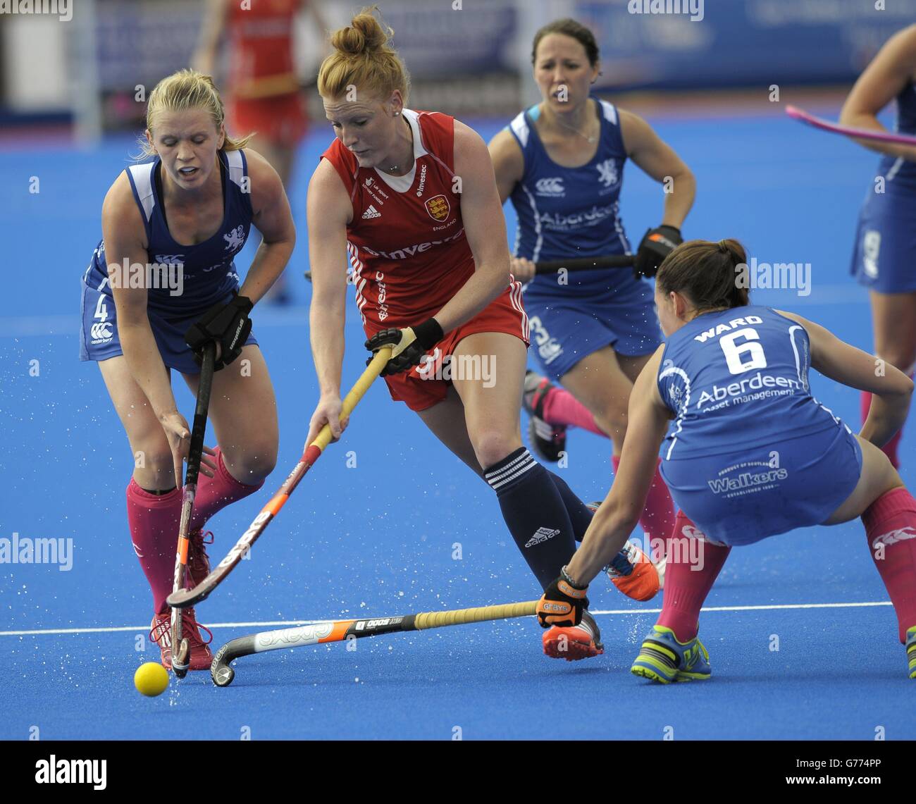England's Nicola White runs through the Scottish defence Morag McLellan (left) and Becky Ward during the Investec London Cup game at the Lee Valley Hockey and Tennis Centre in Queen Elizabeth Park, London. Stock Photo