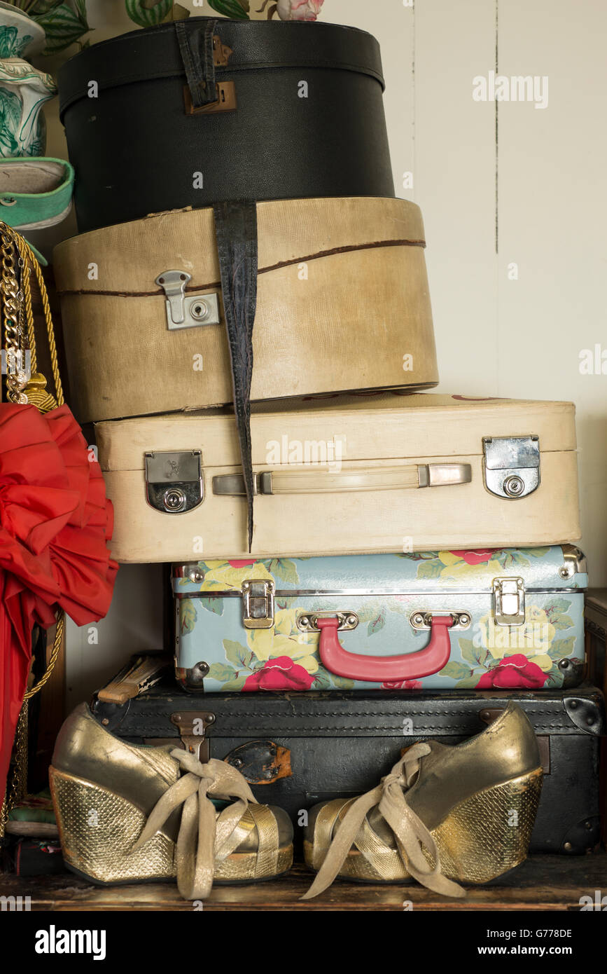 A stack of vintage round and rectangular suitcases and a pair of golden  shoes Stock Photo - Alamy