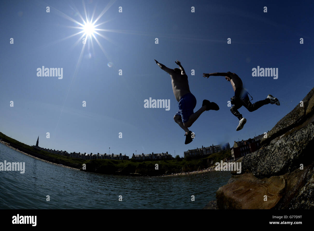 PLEASE NOTE: SHOT USING FISHEYE LENS People jump in the water at Cullercoats, North Tyneside as temperatures hit the high 20s. Stock Photo