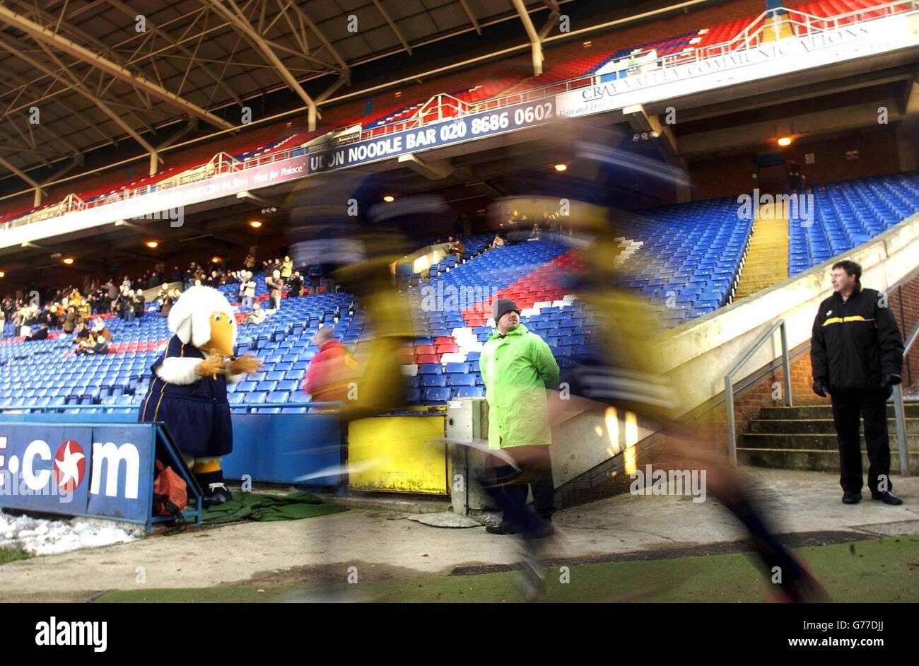 The ghosted figures of two Wimbledon players run out on to the pitch in front of a near empty stand, during the Nationwide Division One match between Wimbledon and Grimsby at Wimbledon's Selhurst Park ground in London. NO UNOFFICIAL CLUB WEBSITE USE. Stock Photo