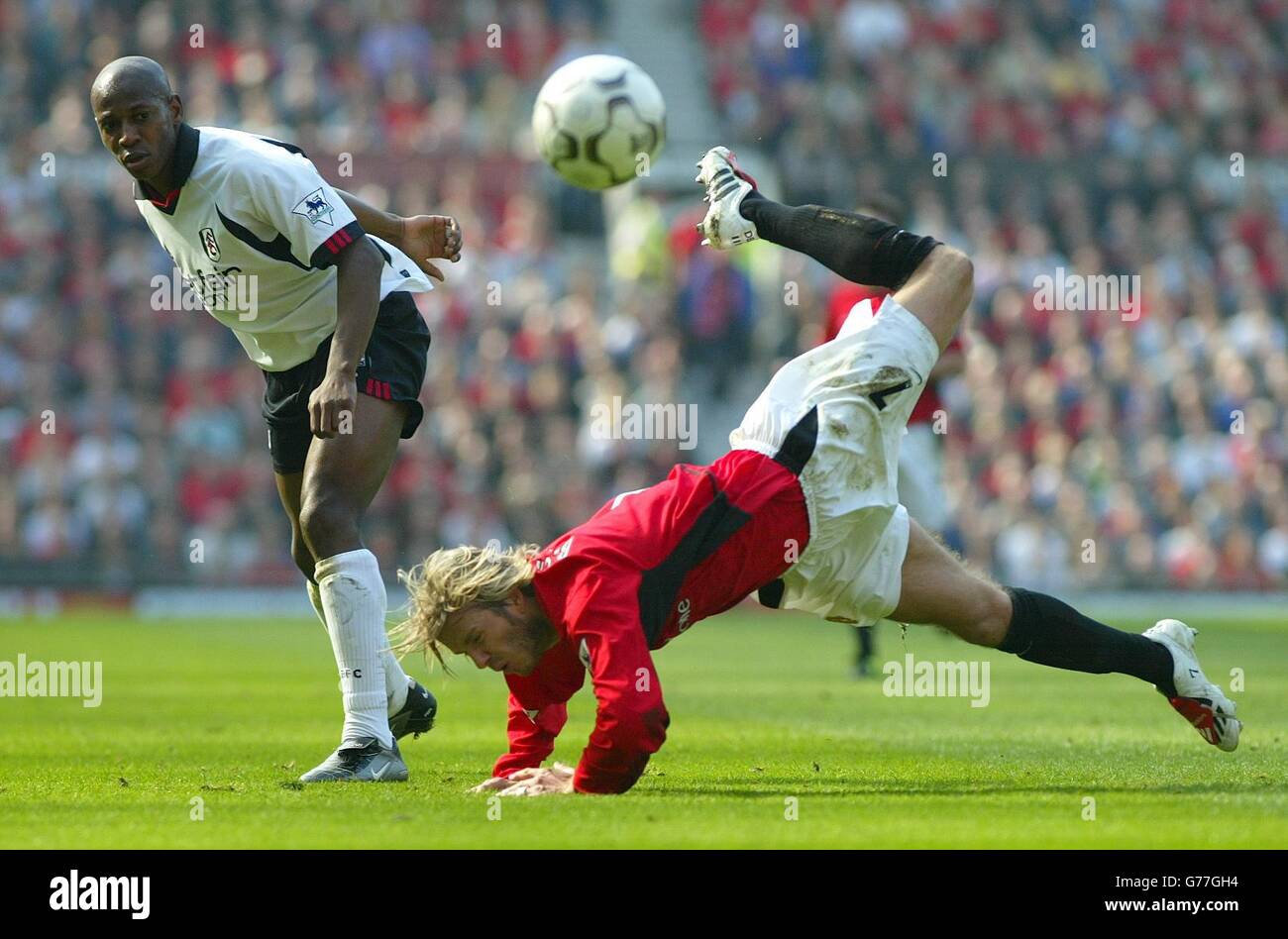 Manchester United's David Beckham falls over from a challenge from Fulham's Luis Boa Morte (left) during the Barclaycard Premiership match at Old Trafford, Manchester. Stock Photo