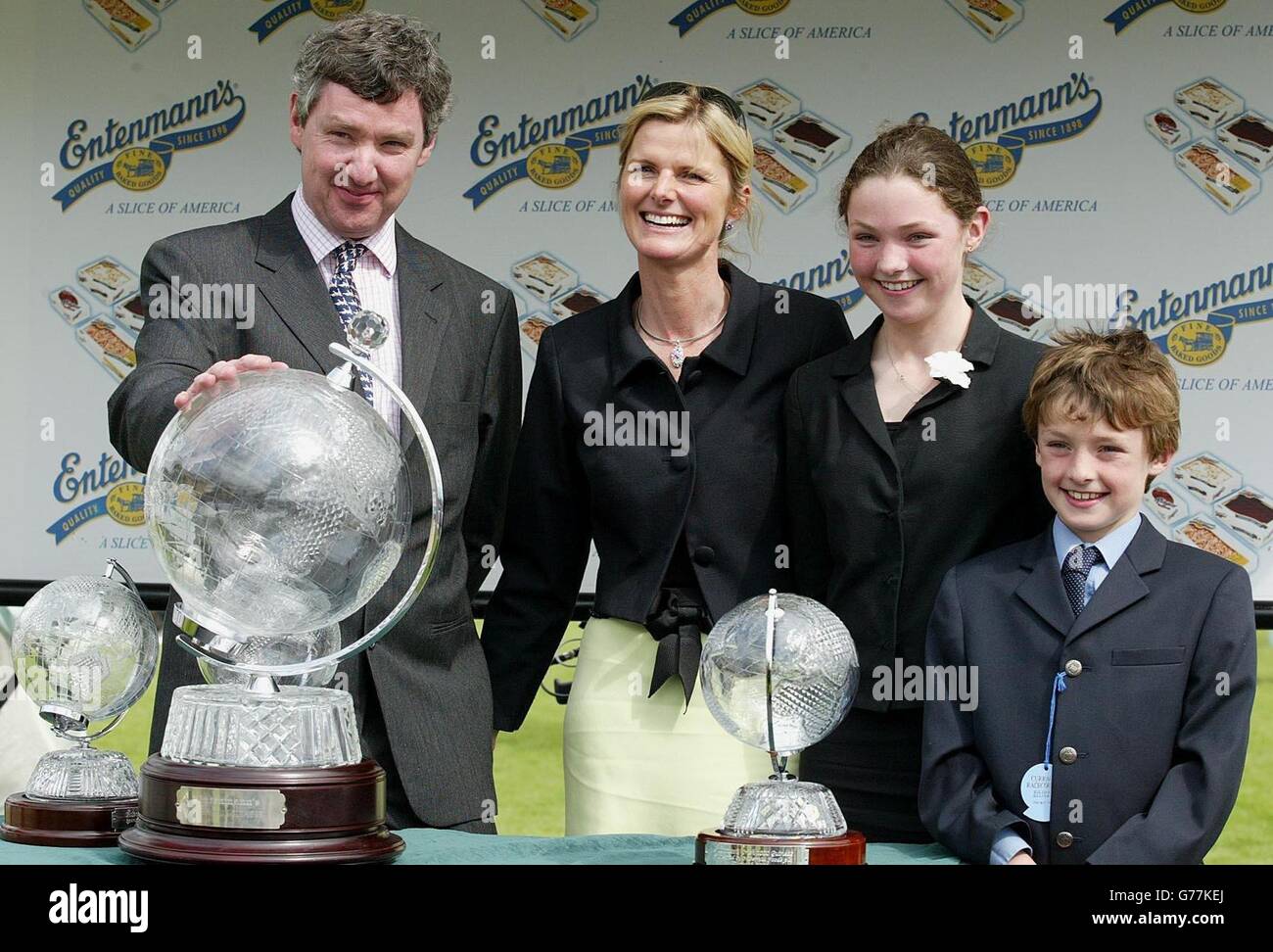 Roisin Henry, part owner of the Entenmann's Irish 1,000 Guineas winner Yesterday, accompanied by her children Nicola and Gregory, is presented with a trophy by Oliver Murphy, chief executive of race sponsor's Hibernia. Stock Photo