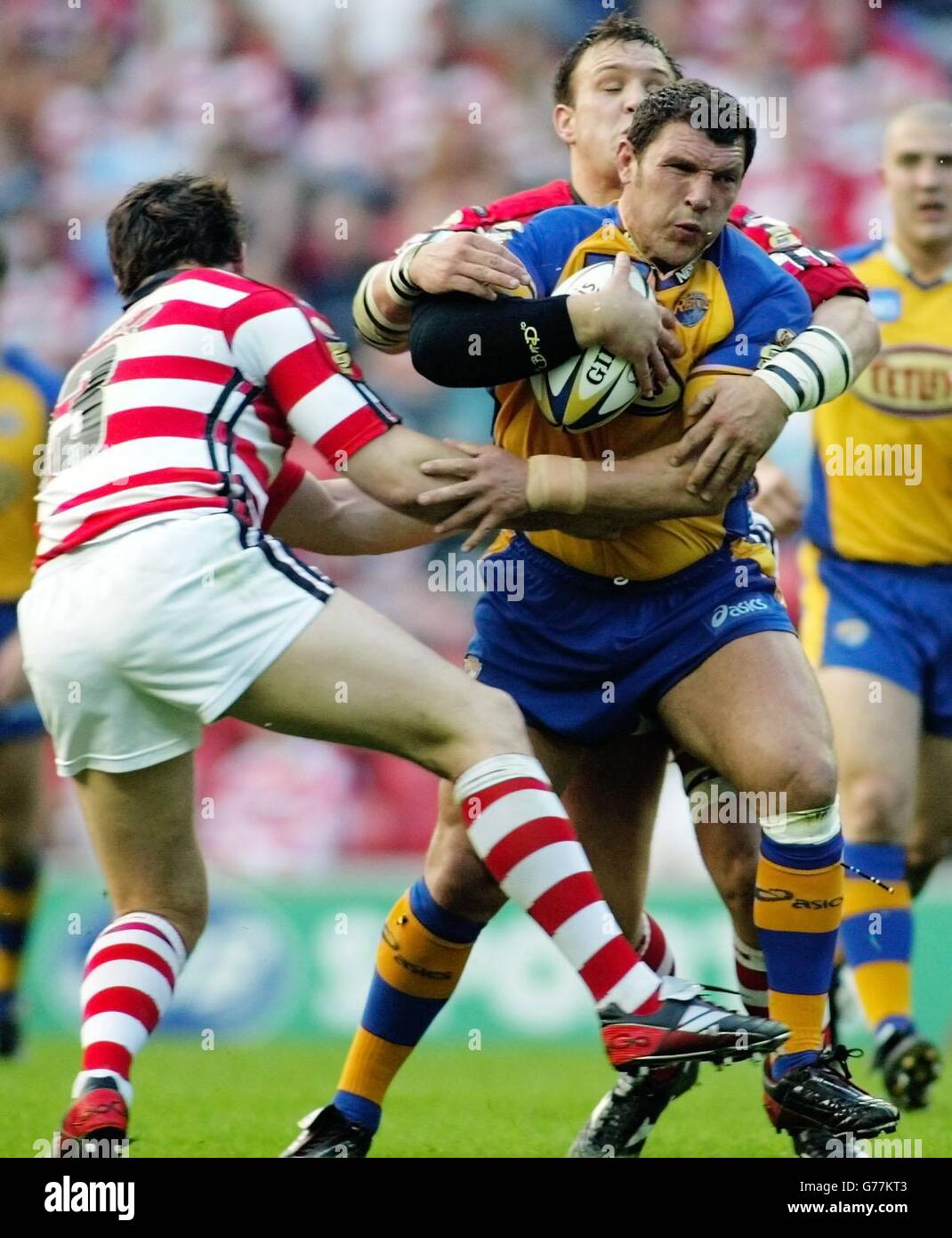 Wigan's Andrew Farrell (lef) and Danny Sculthorpe tackle Leeds's Barrie McDermott, during their Tetley Bitter Super League game at the JJB Stadium, Wigan. Stock Photo