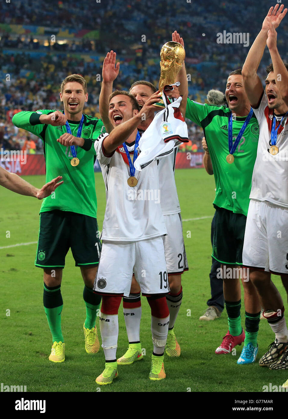 Germany celebrate as goalscorer Mario Gotze holds the trophy following their World Cup final victory over Argentina Stock Photo
