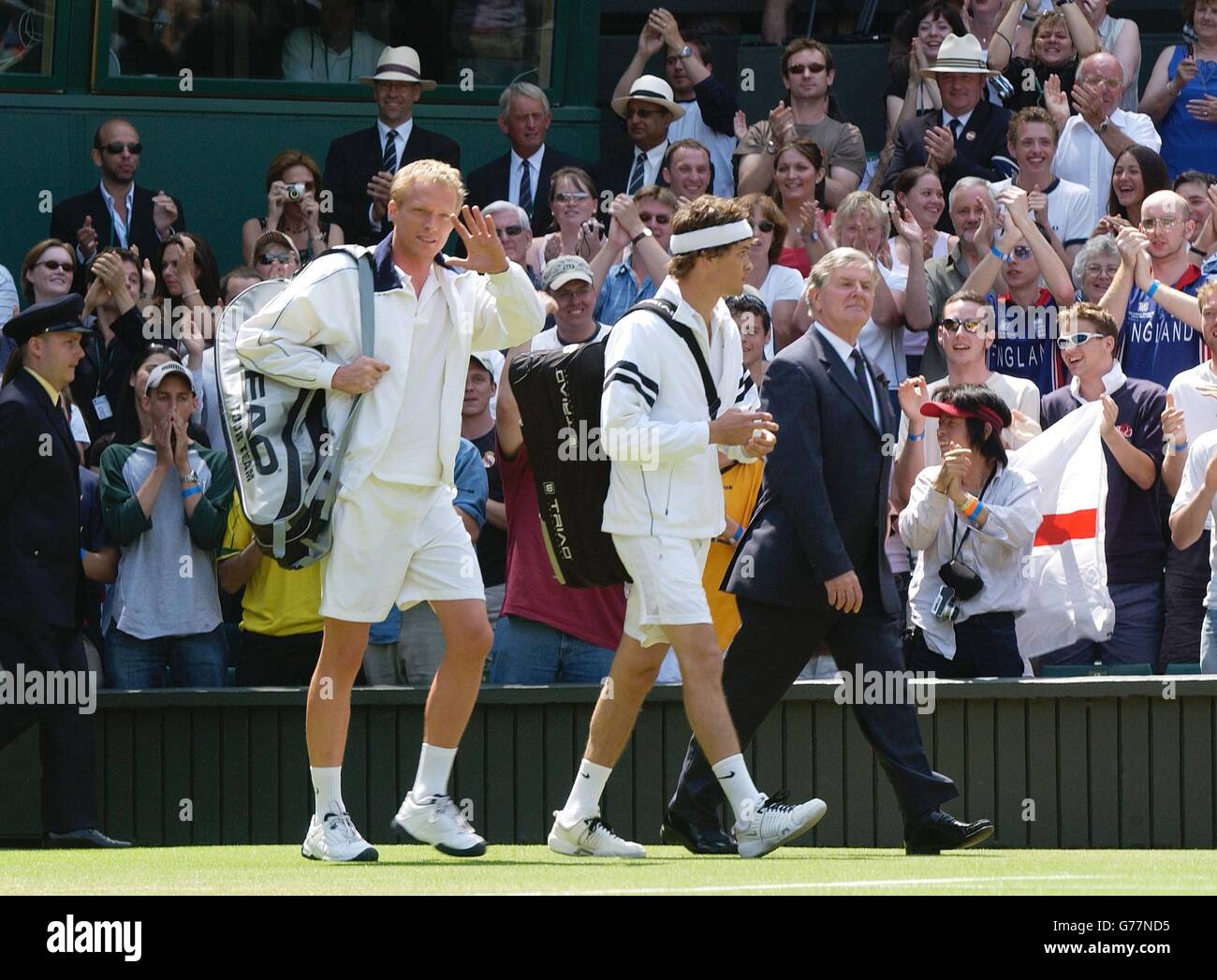 British actor Paul Bettany waves as he walks onto Wimbledon's Centre Court at the All England Lawn Tennis Championships during filming for a movie about the world famous tournament which he stars in with Spiderman actress Kirsten Dunst. The actor also featured alongside Russell Crow in 'A Beautiful Mind'. Stock Photo