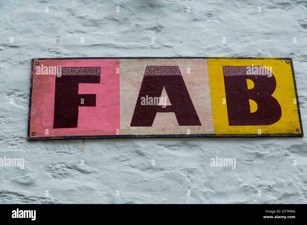 The word FAB or F A B white rough stone wall background. Stock Photo