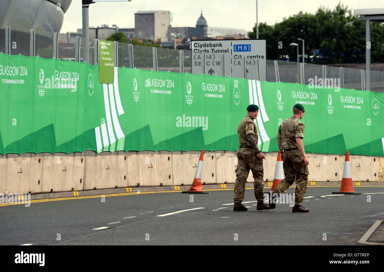 British soldiers walk around the security barrier surrounding the Commonwealth Games venue in Glasgow ahead of the Games which begin on Wednesday with the Opening Ceremony. Stock Photo