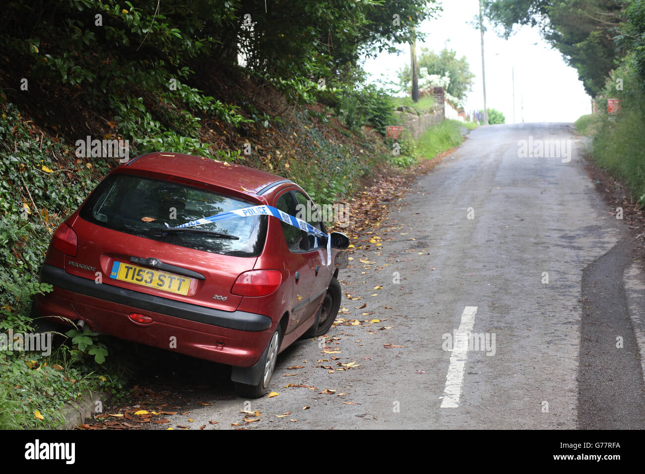 Abandoned red car with Police tape across it, Sandford, Somerset, England, UK June 2016 Stock Photo