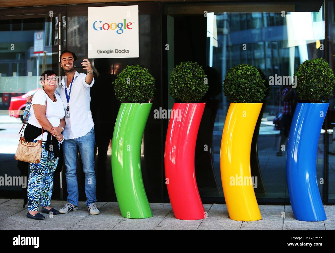 People take a selfie outside Google headquarters known as the Googleplex on Dublin's Barrow Street, as Jobs Minister Richard Bruton has defended luring companies to Ireland after US president Barack Obama accused multinationals of relocating to exploit unpatriotic tax loopholes. Stock Photo