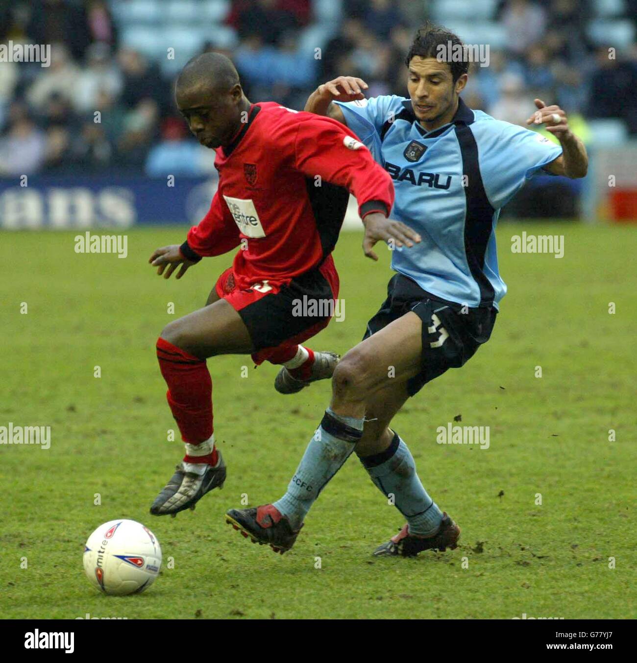 Damien Francis of Wimbledon evades the challenge from Youssef Chippo of Coventry City , during the Nationwide Division One match at The Highfield Road Stadium, Coventry. NO UNOFFICIAL CLUB WEBSITE USE. Stock Photo