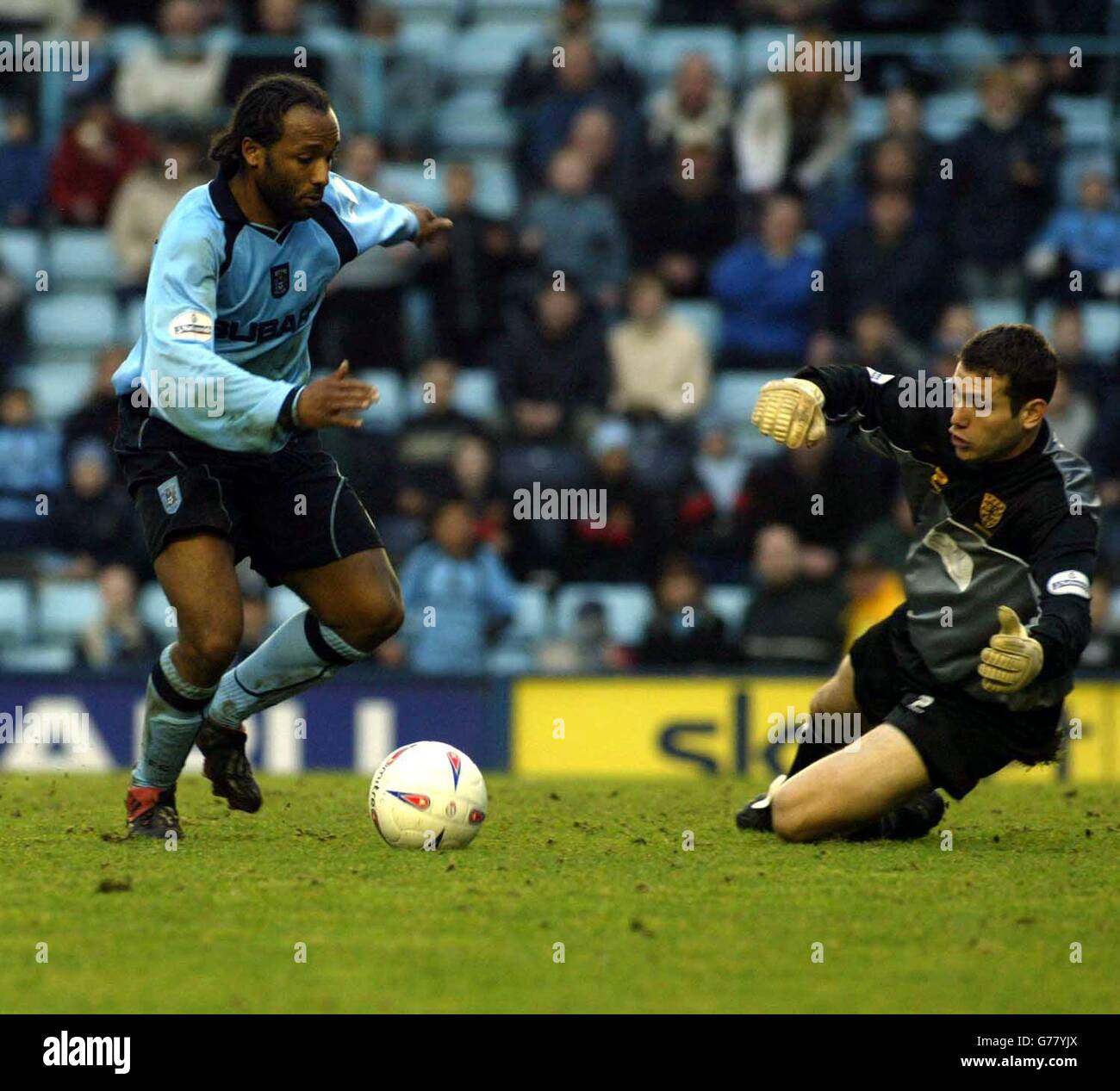 Coventry's Julian Joachim (left) rounds the Wimbledon goal-keeper to score for his team, during the Nationwide Division One match at The Highfield Road Stadium, Coventry. Final score: Coventry 2, Wimbledon 2. NO UNOFFICIAL CLUB WEBSITE USE. Stock Photo