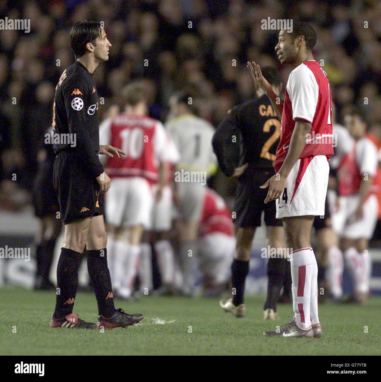 As Roma's Francesco Totti is shown the red card after an incident with Martin Koewn, Roma's Christian Panucci and Arsenal's Thierry Henry exchange opionions of the incident, during their Champions League 2nd Round Group A match at Highbury in North London. Stock Photo