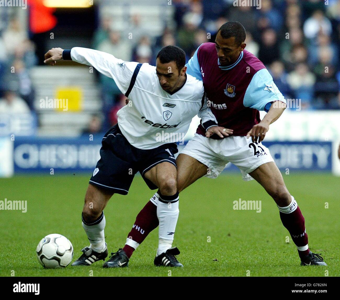 Bolton Wanderers' Youri Djorkaeff (left) holds off West Ham United's Edouard Cisse, during the Barclaycard Premiership match at the Reebok Stadium, Bolton. Stock Photo