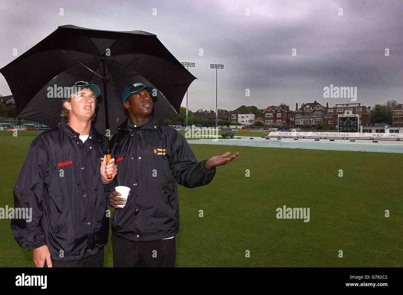 Zimbabwe cricketers Barney Rogers (left) and Vusi Sibanda look for a break in the weather at the County Ground in Hove, Sussex. There has been no play today with Zimbabwe on 317 - 4. Stock Photo