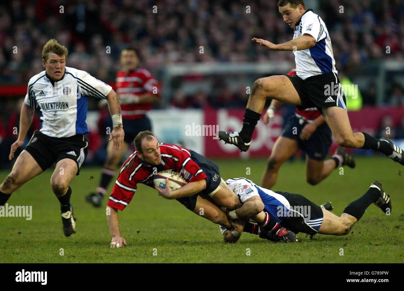 Gloucester's Ludovis Mercier is tackled by Bath's Mike Catt as Ollie Barkley jumps over them, during the Zurich Premiership match at Gloucester's Kingsholm stadium. Stock Photo